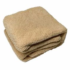 two tan towels stacked on top of each other in front of a white background,