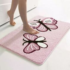 a person standing on a pink rug with butterfly design in the middle and feet sticking out