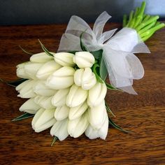 a bunch of white flowers sitting on top of a wooden table