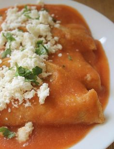 a white plate topped with ravioli covered in gravy and parmesan cheese