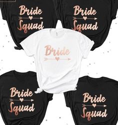 four bride squad shirts with arrows and hearts on the front, three are black and one is white