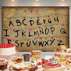 a table topped with lots of cakes and pastries next to a sign that says abcdef