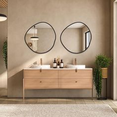 two round mirrors are above the double sink vanity in this modern bathroom with beige walls and flooring