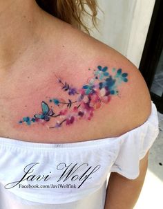 the back of a woman's shoulder with watercolor flowers and butterflies on it