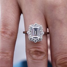 a woman's engagement ring with an emerald cut diamond