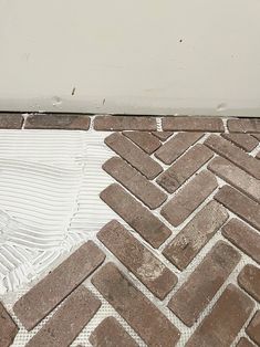 a white toilet sitting on top of a brick floor