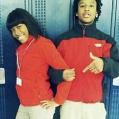 two people standing next to each other in front of lockers