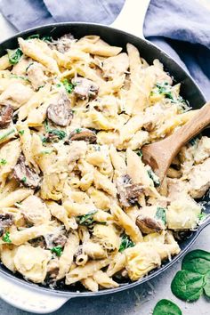 a skillet filled with pasta and mushrooms