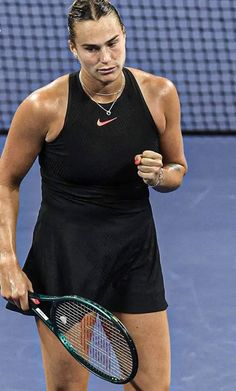 a woman holding a tennis racquet on top of a tennis court