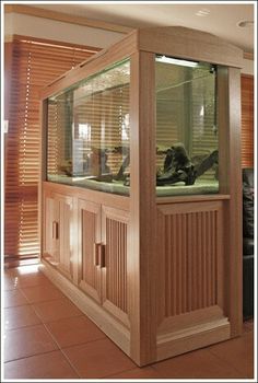 a large fish tank sitting inside of a wooden cabinet