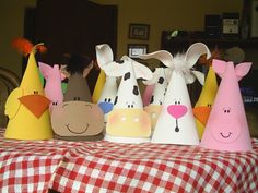 several paper hats with animals on them sitting on a table in the middle of a room