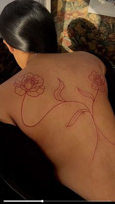 the back of a woman's body with flowers on it, and an arrow drawn in red ink