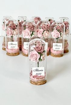 pink roses in glass jars with labels on them