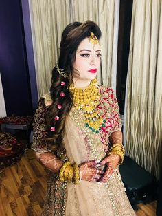 a woman wearing a bridal outfit and jewelry