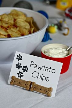 a bowl of chips next to a sign that says pawato chips with a dog bone on it