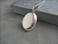 Classic beautiful silver medallion. It is polished very smooth, oval and flat. The large centre is elegantly raised. The silver stamp is applied to the inner rim. The Venetian chain is 50 cm long and is also made of genuine 925 sterling silver (optional). The necklace  is about 1.3 grams light.   + Dimensions: approx. 20 x 14 x 3 mm + Material: 925 Sterling Silver polished + Stamped + High quality workmanship + Chain: 50 cm + Weight: approx. 4.4 gram medallion amulet flat simple 925 silver oval Formal White Gold Oval Pendant Locket Necklace, Classic Sterling Silver Oval Locket Necklace, Formal Sterling Silver Locket Necklace With Polished Finish, White Oval Pendant With Polished Finish, Classic Sterling Silver Oval Link Locket Necklace, Classic Silver Oval Link Locket Necklace, Classic Silver Locket Necklace With Oval Link, Elegant Sterling Silver Locket Necklace With Oval Link, Oval Sterling Silver Locket Necklace