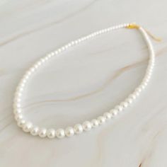 Queen Liz Graduated Pearl Necklace - Rocca & Co Elegant Single Strand Cream Pearl Necklace, Elegant Cream Single Strand Pearl Necklace, Classic Cream Pearl Necklace With Pearl Charm, Classic Cream Necklace With Pearl Chain, Classic Cream Pearl Chain Necklace, Classic Cream Necklaces With Round Beads, Classic Cream Pearl Necklace, Classic Pearl White Necklace With Pearl Drop, Cream Single Strand Pearl Necklace