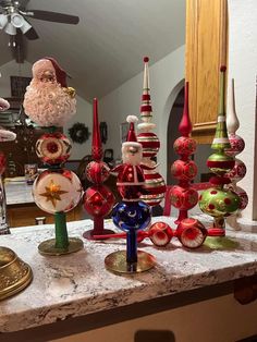 christmas ornaments are sitting on a counter top in front of a ceiling fan and mirror