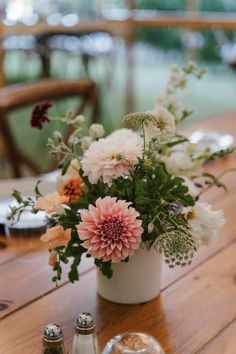 a vase filled with flowers sitting on top of a wooden table