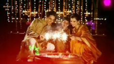 a man and woman sitting next to each other in front of a table with sparklers on it