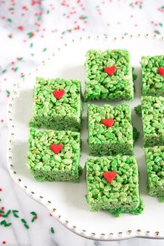 green rice krispy treats on a white plate with red heart cut out in the middle