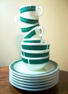 stack of white and green dishes stacked on top of each other