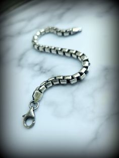 We call this gift-worthy piece our Paved Path Bracelet, a wearable reminder of the beauty in the continuity and confidence of choosing to stay on the path one has paved in life. The solid links of Sterling are approximately 5mm in width. A beautiful, fluid, comfortable piece, showcasing the malleability and the strength of one of the most beloved metals found in our Earth, Sterling. Finished with an industrial style Sterling Lobster Claw style Clasp, approximately 1/2" or 12mm in length connecti Luxury Stainless Steel Box Chain Bracelet, Timeless Bracelet With Rectangular Links As Gift, Everyday White Gold Bracelets With Rectangular Links, White Gold Jewelry With Rectangular Links As A Gift, White Gold Jewelry With Rectangular Links For Gifts, Everyday White Gold Chain Bracelet, Luxury Everyday Sterling Silver Chain Bracelet, Everyday Luxury Sterling Silver Chain Bracelet, Everyday Spiritual Metal Bracelets