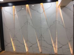 a white marble wall with some lights on it