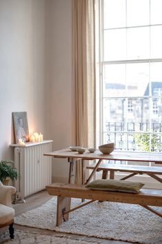 a living room filled with furniture and a table next to a window covered in curtains