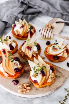 pear and whipped goat cheese sweet potato rounds on a cutting board with walnuts in the background