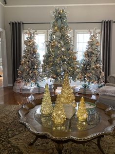 a living room decorated for christmas with gold and silver trees