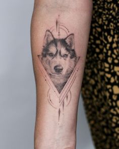 a tattoo on the arm of a woman with a wolf's head in it