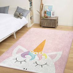 a pink rug with an unicorn face on it