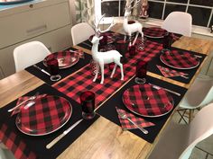 the table is set with red and black buffalo plaid placemats, silverware, and deer figurines