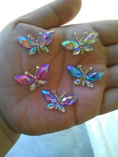 four different colored jewels in the palm of someone's hand