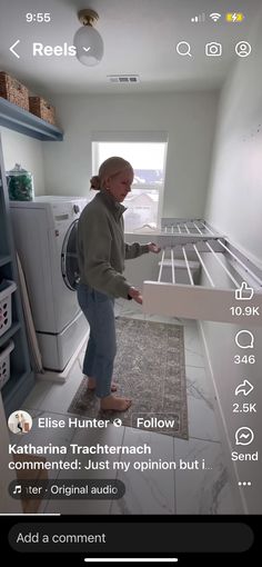 a woman standing next to a washer and dryer in a room