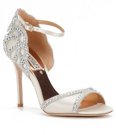 a pair of white high heeled shoes with crystal embellishments