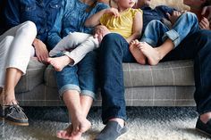 a group of people sitting on top of a couch with their feet propped against each other