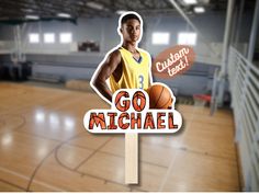 a basketball player standing in front of a go michael sign on a wooden sticker