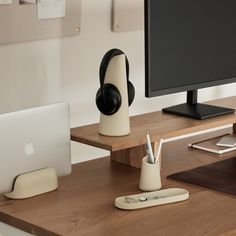 an apple computer sitting on top of a wooden desk next to a white macbook