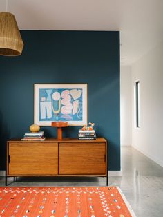 a living room with an orange rug and blue walls