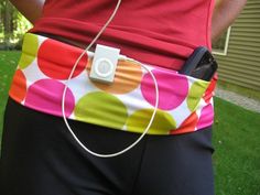 a woman is holding her cell phone in her back pocket while wearing a colorful polka dot belt