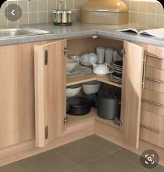 an open cabinet in the corner of a kitchen