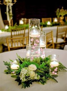 a table with candles and flowers on it in front of the words floating pearls, vases for decoration