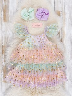 This shimmery tulle dress is perfect for little girls who love to twirl and shine! With tiers of sequin sparkle tulle in delightful pastel colors, she'll feel like a true fairy princess. Turn any occasion into a magical one with this whimsical dress. Fits true to size. 95% Polyester / 5% Spandex 100% Polyester Accessories sold separately. Suggest bow color #58 and #65 Import. Aurora is 30 inches tall and 25 lbs wearing size XS 18-24 months. **Afterpay and Sezzle Purchase Requires $35 Minimum Ord Pink Glitter Sequin Dress For Dress-up, Pink Sequin Dress For Dress-up, Pink Sparkly Sequin Dress For Dress-up, Spring Dress With Ruffles And Glitter Tulle, Pink Glitter Tulle Tutu Dress For Spring, Princess Style Multicolor Fairy Dress For Summer, Spring Pink Glitter Tulle Tutu Dress, Playful Sequin Party Dresses, Playful Sequined Party Dress