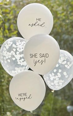 white balloons with black writing on them that say she said yes, we're engaged