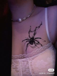 a woman's stomach with a tattoo of a spider on her chest and bra