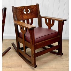 a wooden rocking chair sitting on top of a hard wood floor next to a white wall