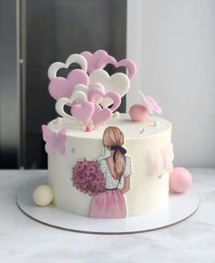 a white cake decorated with pink and white hearts on it's side, sitting on top of a table