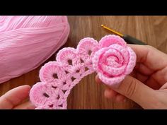 someone is crocheting two pink flowers together